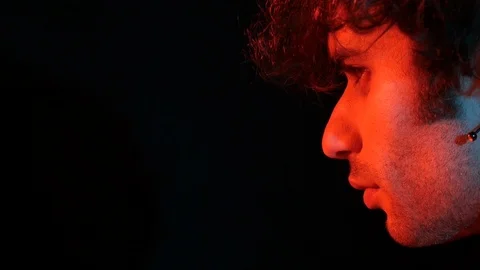 Young man profile with red light on black background	 Stock Footage 126857266