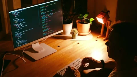 A young man programmer coding on a laptop Stock Footage 274096186
