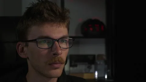 Young man programmer in eyeglasses is working on laptop computer at late night. Stock Footage 138081715