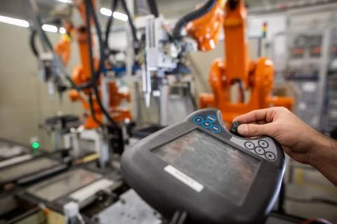 Young man programming industrial automatic robot in automotive industry 写真素材