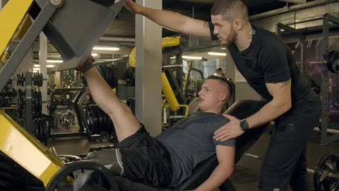 Young man with prosthetic leg using leg press machine in gym Stock Footage 125531027