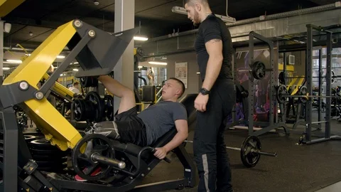 Young man with prosthetic leg using leg press machine in gym Stock Footage 125532072