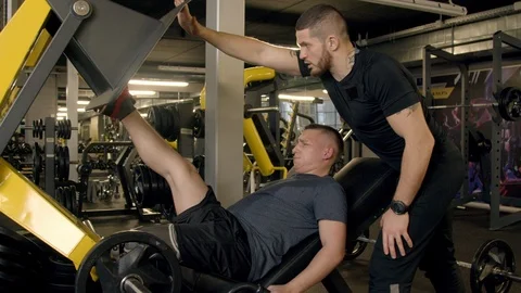 Young man with prosthetic leg using leg press machine in gym Stock Footage 125532469