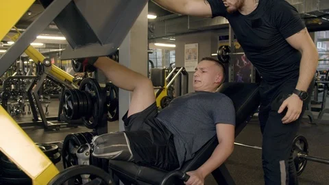 Young man with prosthetic leg using leg press machine in gym Video stock 125532508
