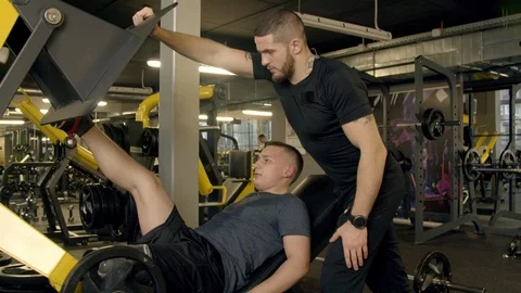 Young man with prosthetic leg using leg press machine in gym Stock Footage 125532625