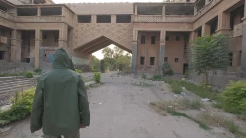 A young man in a protective cloak and in a respirator walks through the Stock Footage 242421417