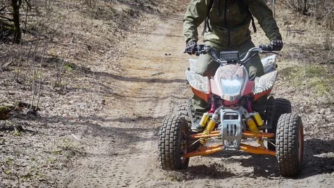 A young man in a protective helmet on his head rides a quad bike in a zigzag Stock Footage 75388350
