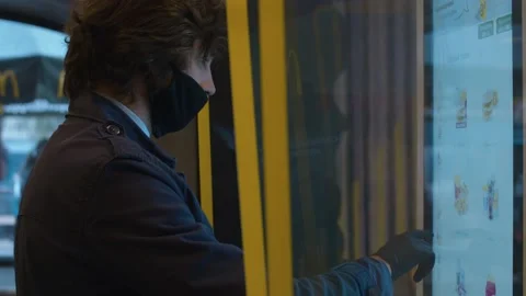 Young man in a protective mask choosing food at a self-service touch terminal Stock Footage 141338015