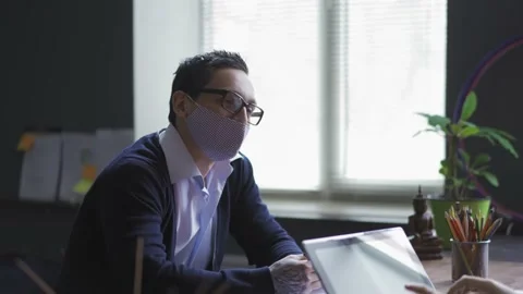 Young man in protective mask have job interview sitting in front of a woman in Stock Footage 130880865