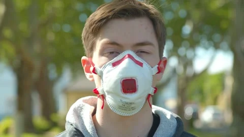 Young Man with Protective Mask looking into Camera / Social Distancing Outdoors  Vídeos de archivo 131929776
