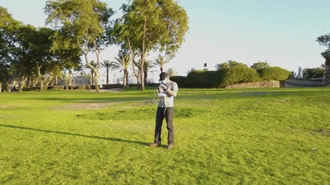 Young man with protective mask, remote control in hand to fly a drone, outsid Stock Footage 134497740