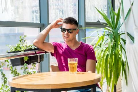 Young man in the pub. Drinking beer, eating pizza. Stock Photos