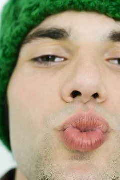 Young man puckering lips, looking at camera, cropped view Stock Photos