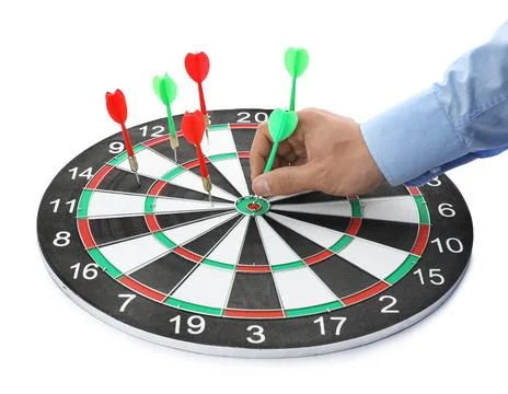 Young man pulling dart out of board on white background, closeup Stock Photos
