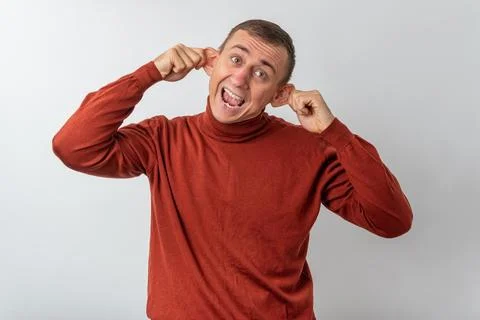 Young man pulling his ears and shouting with mouth wide open, making a goof.. Stock Photos
