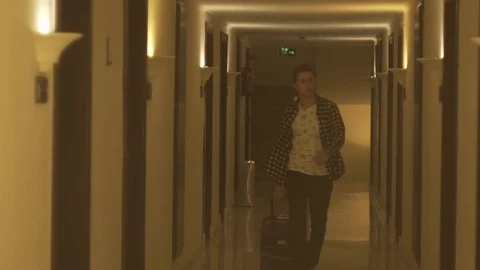 Young man pulling suitcase in the hotel Video stock 73975381