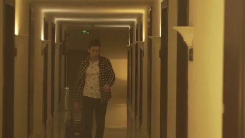 Young man pulling suitcase in the hotel Stock Footage 73975476