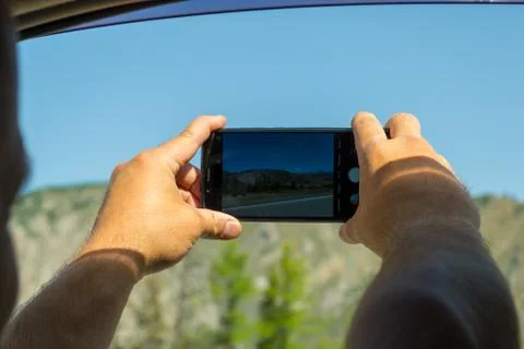 A young man pulling two hairy hands into the open window of a moving car hold Stock Photos
