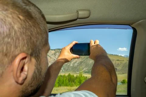 A young man pulling two hairy hands into the open window of a moving car hold Stock Photos