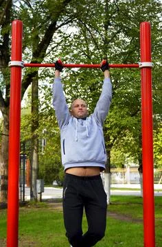 Young man pulls up on the bar during workout, outdoor sports Foto stock