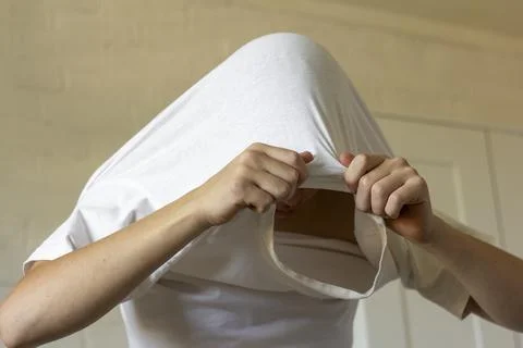 The young man pulls his T-shirt over his head,undresses. Stock Photos