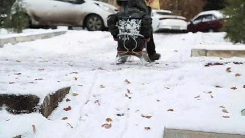 A young man pulls a sled through the snow with his young son. There are trees Stock Footage 308386637
