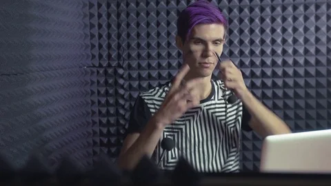 Young man with purple bangs putting on the head a microphone in sound studio Stock Footage 70792479