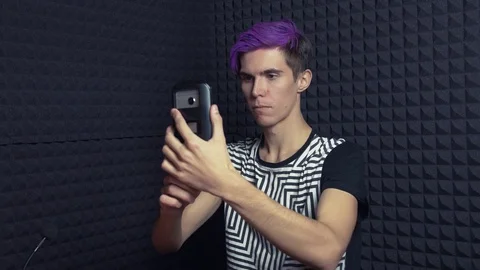 Young man with purple bangs taking selfie in sound studio Stock Footage 70804669