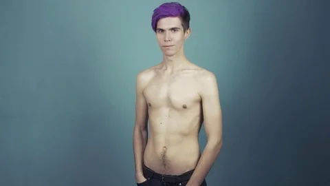 Young man with purple bangs topless in studio on gray background Stock Footage 70976759