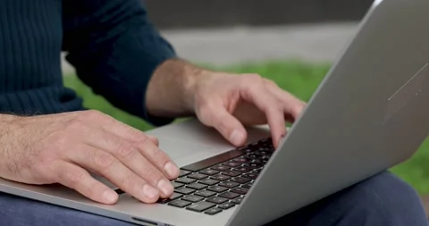 Young man pushing buttons on keyboard of modern laptop. Close up of male hands Stock Footage 140681433