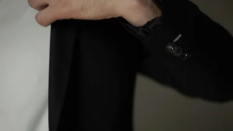 Young man put on classical suit black jacket Stock Footage 93849090