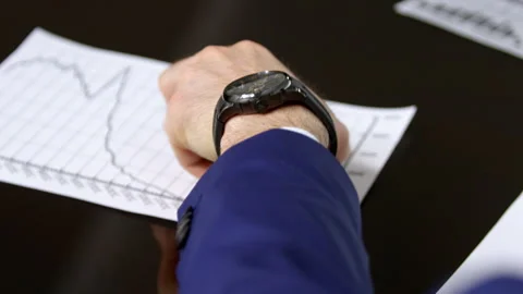 Young man puts and takes cell phone in hand in meeting Stock Footage 243297757