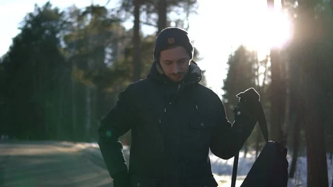 Young man puts on a backpack in the woods. Video stock 93322341