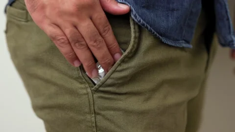  A young man puts a condom in his pants pocket to prepare for use. Campaign for  Stock Footage 161234744