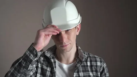 A young man puts on a construction helmet. close-up. isolated. Stock Footage 236689697