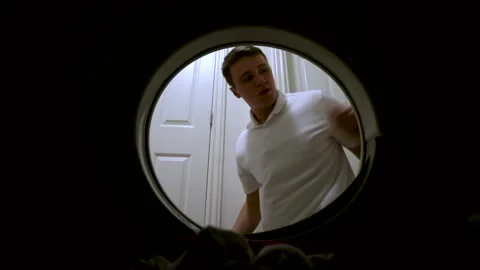 Young Man Puts Dirty Laundry In The Washing Machine. - close up shot Stock Footage 143515977