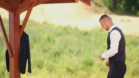 Young man puts on his jacket. Gatherings of the groom. Wedding day. Stock Footage 94893460