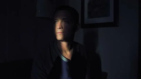 Young man puts on mask on his face in front of the window Stock Footage 137352113