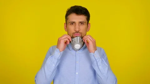 Young man puts on a protective mask on yellow background Stock Footage 124906127