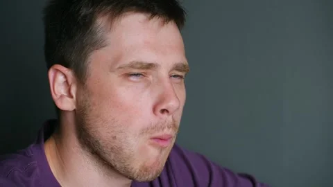 Young man puts sushi roll into mouth with chopsticks chewing Video stock 282644240
