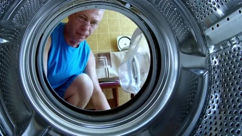 Young man puts things in the washing machine action camera close-up Stock Footage 112608462