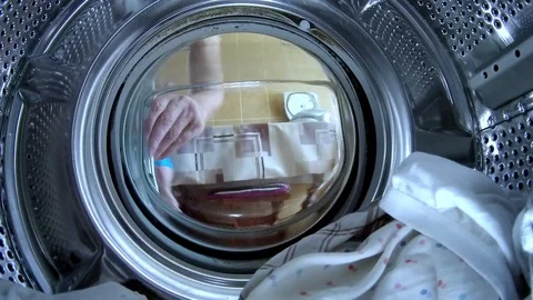 Young man puts things in the washing machine action camera close-up Vidéo 113219142