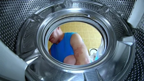 Young man puts things in the washing machine action camera close-up Stock Footage 113219160
