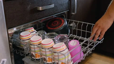 Young man putting dirty cups in dishwasher Stock Footage 249445028
