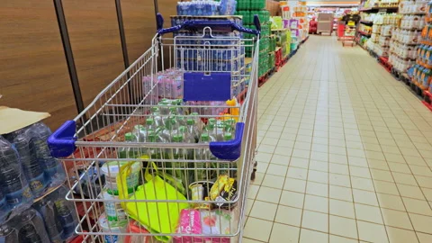 Young man putting groceries and water in cart at Aldi, Dijon, France. Vídeos de archivo 329439341