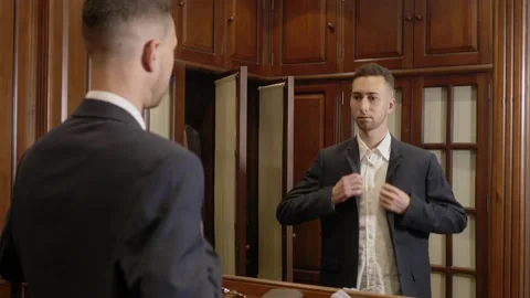 Young man putting on jacket in dressing room Stock-Footage 159779340