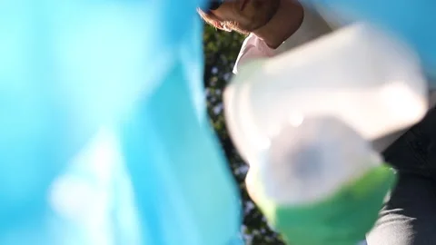 Young man is putting plastic trash in bag at green park on summer day spbi. Stock Footage 139048908