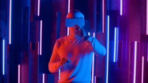 Young Man putting VR headset on the viewer in neon lights Stock Footage 123876366