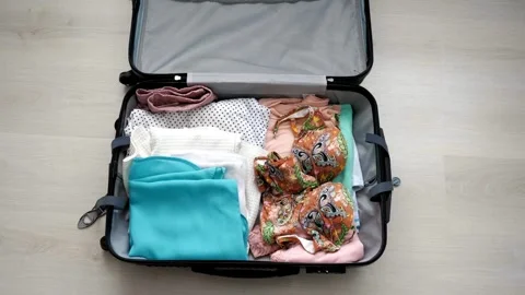 Young man quickly packing travel suitcase and running in living room at home 스톡 동영상 336248181