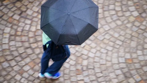 Young man with rain umbrella walking on old town market square in Lviv, Ukraine Vídeos de archivo 112586700